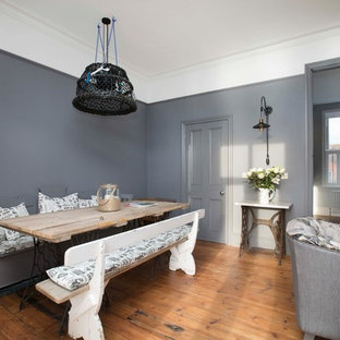 Offenes, Großes Shabby-Look Esszimmer mit grauer Wandfarbe, braunem Holzboden, braunem Boden, Kamin und Kaminumrandung aus Metall in Kent