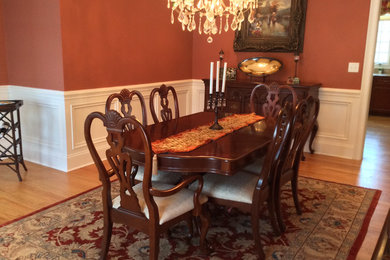 Example of a mid-sized classic light wood floor and brown floor enclosed dining room design in New York with red walls and no fireplace
