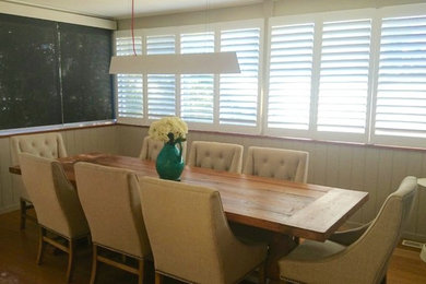 Réalisation d'une salle à manger ouverte sur le salon marine de taille moyenne avec un mur gris, parquet foncé et un sol marron.
