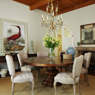 Foto di una sala da pranzo mediterranea chiusa con pareti beige, pavimento in legno massello medio, camino classico e cornice del camino in pietra