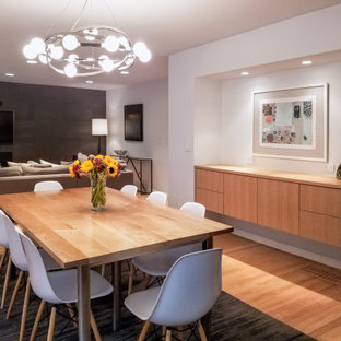 Idée de décoration pour une grand salle à manger ouverte sur le salon avec un mur gris, un sol en bois clair, une cheminée standard, un manteau de cheminée en carrelage et un sol bleu.