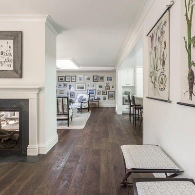 Inspiration for a mid-sized farmhouse dark wood floor great room remodel in San Francisco with white walls, a two-sided fireplace and a stone fireplace