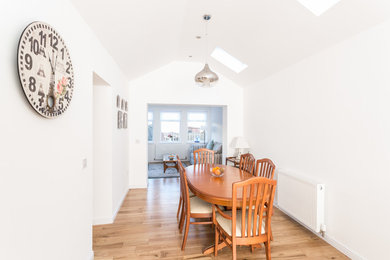 Design ideas for a small traditional open plan dining room in Glasgow with white walls and light hardwood flooring.