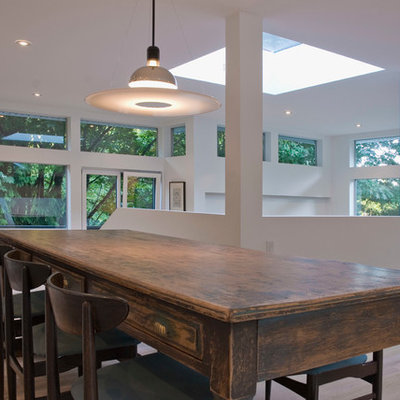 Example of a trendy medium tone wood floor dining room design in Vancouver with white walls