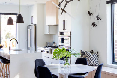 Foto på ett funkis kök med matplats, med vita väggar, mellanmörkt trägolv och brunt golv