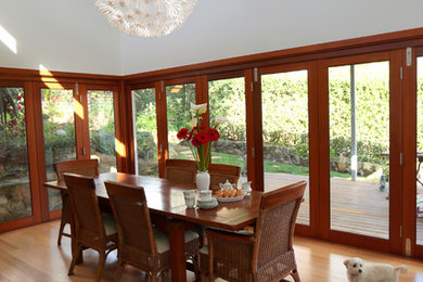 Inspiration pour une grande salle à manger ouverte sur la cuisine design avec un mur gris et un sol en bois brun.