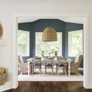 Foto di una sala da pranzo moderna di medie dimensioni con pareti blu, parquet scuro, camino ad angolo, cornice del camino in mattoni e pavimento marrone