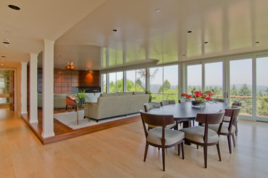 Foto di una sala da pranzo aperta verso la cucina moderna di medie dimensioni con pareti bianche, parquet chiaro, nessun camino e pavimento beige