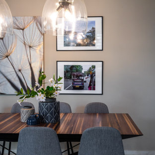 Immagine di una sala da pranzo con pareti grigie, pavimento in gres porcellanato, camino lineare Ribbon e cornice del camino in perlinato
