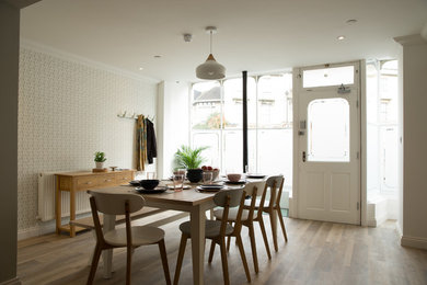 Large scandi open plan dining room in Wiltshire with white walls and lino flooring.