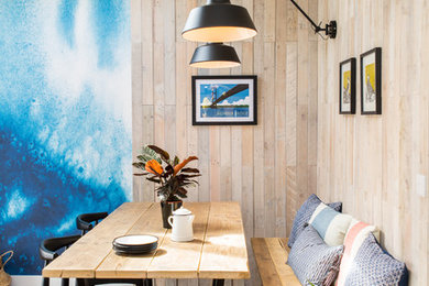 Ispirazione per una sala da pranzo aperta verso la cucina design di medie dimensioni con pavimento in laminato, pavimento marrone, pareti blu e pannellatura