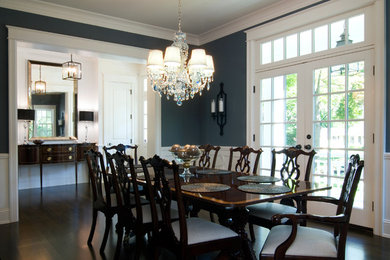На фото: большая отдельная столовая в классическом стиле с синими стенами и темным паркетным полом без камина с