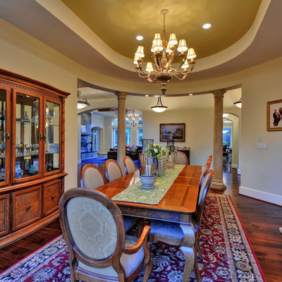 Example of a tuscan dark wood floor dining room design in San Francisco with beige walls and a standard fireplace