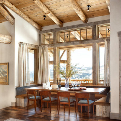 Example of a mid-sized mountain style dark wood floor and brown floor kitchen/dining room combo design in Other with white walls