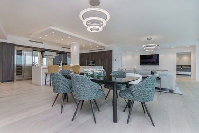 Large contemporary dining room in Miami with white walls, light hardwood flooring and beige floors.