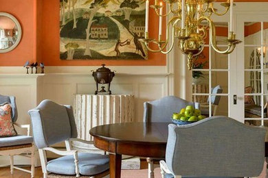 Inspiration for a timeless medium tone wood floor enclosed dining room remodel in Boston with orange walls