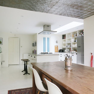 Ispirazione per una sala da pranzo aperta verso la cucina boho chic con pareti bianche, pavimento in legno verniciato e pavimento bianco