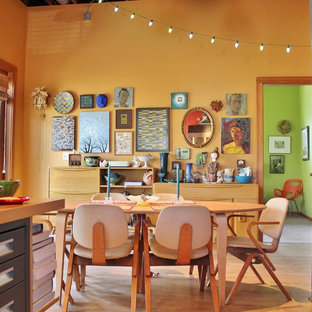 Esempio di una sala da pranzo aperta verso la cucina bohémian con pareti gialle e nessun camino