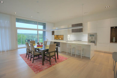 Imagen de comedor de cocina grande con paredes blancas y suelo de madera clara