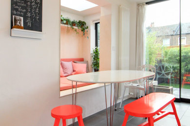 На фото: маленькая столовая в современном стиле с с кухонным уголком, белыми стенами, полом из керамической плитки и черным полом для на участке и в саду с