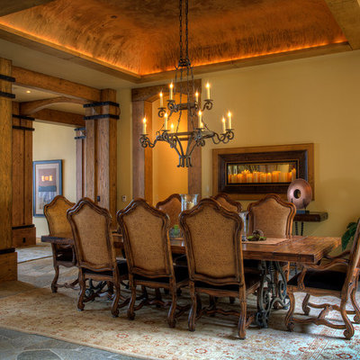 Example of a large mountain style dark wood floor enclosed dining room design in Other with beige walls
