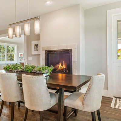 Example of a mid-sized farmhouse dark wood floor kitchen/dining room combo design in San Francisco with gray walls, a standard fireplace and a stone fireplace