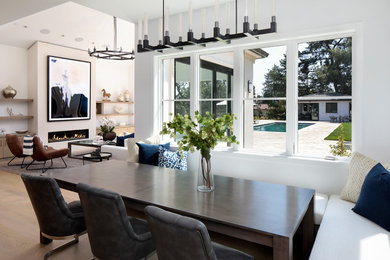 Photo of a traditional open plan dining room in San Francisco with white walls, medium hardwood flooring, a ribbon fireplace and brown floors.