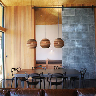 Idee per una sala da pranzo aperta verso il soggiorno moderna di medie dimensioni con pareti con effetto metallico, pavimento in cemento e nessun camino