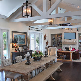 Foto di una sala da pranzo stile rurale con pareti beige, parquet scuro, camino classico, cornice del camino in pietra e pavimento marrone