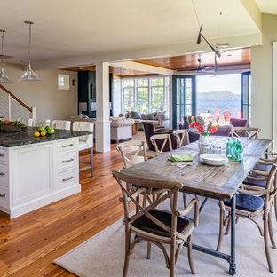 Imagen de comedor de estilo americano, grande, abierto, con paredes grises, suelo de madera en tonos medios y suelo marrón