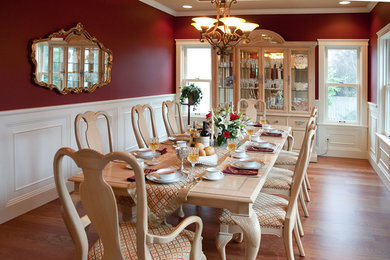 Ejemplo de comedor tradicional con paredes rojas y suelo de madera en tonos medios