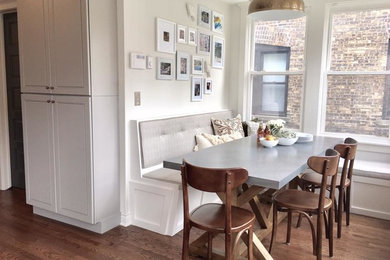 Esempio di una sala da pranzo aperta verso la cucina tradizionale di medie dimensioni con pareti bianche, pavimento in legno massello medio, pavimento marrone e nessun camino