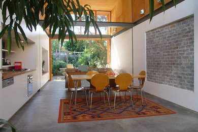 Esempio di una piccola sala da pranzo aperta verso la cucina bohémian con pavimento in cemento