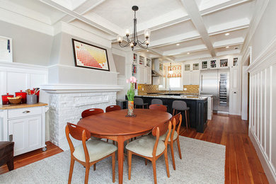 Inspiration pour une salle à manger traditionnelle de taille moyenne avec un mur gris, un sol en bois brun et une cheminée standard.