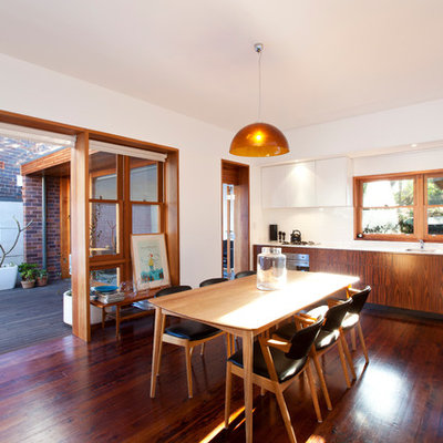 Trendy dark wood floor kitchen/dining room combo photo in Other with white walls
