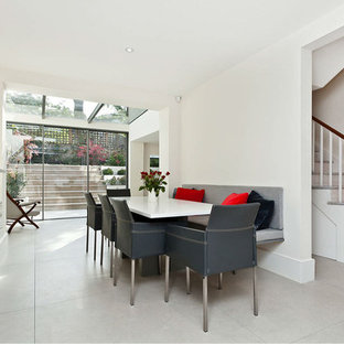Design ideas for a contemporary enclosed dining room in Other with white walls, a standard fireplace and grey floors.