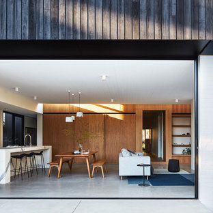 Photo of a contemporary open plan dining in Melbourne with white walls, concrete floors and grey floor.