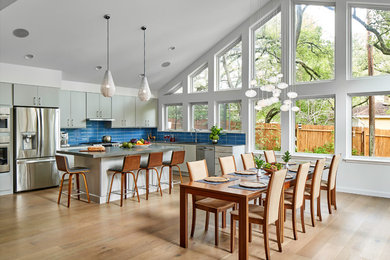 Imagen de comedor de cocina retro grande sin chimenea con paredes blancas, suelo de madera clara y suelo beige