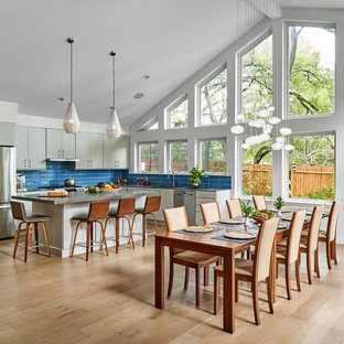 Esempio di una grande sala da pranzo aperta verso la cucina moderna con pareti bianche, parquet chiaro, nessun camino e pavimento beige