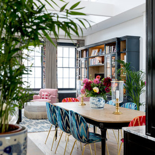 This is an example of a large bohemian open plan dining room in London with grey walls, medium hardwood flooring and brown floors.