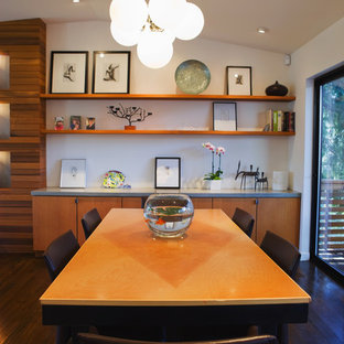 Example of a minimalist dark wood floor dining room design in Portland with white walls