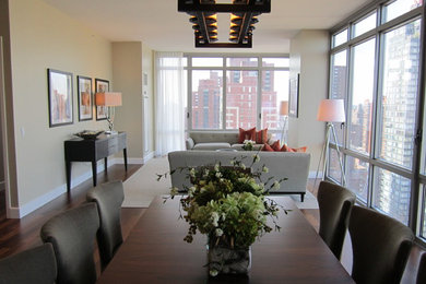 Foto di una sala da pranzo aperta verso il soggiorno tradizionale con pareti beige, pavimento in laminato e pavimento marrone