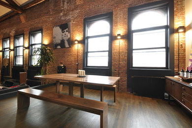 Inspiration for a mid-sized industrial dark wood floor great room remodel in New York with brown walls and no fireplace