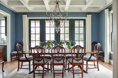 Exemple d'une salle à manger chic avec un mur bleu, un sol en bois brun et un sol marron.