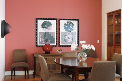 Modelo de comedor contemporáneo grande abierto con suelo de madera clara y paredes rosas