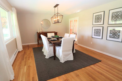 Example of a medium tone wood floor and brown floor enclosed dining room design in Philadelphia with gray walls