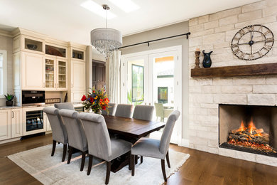 Mid-sized elegant dark wood floor dining room photo in Denver with gray walls, a standard fireplace and a stone fireplace