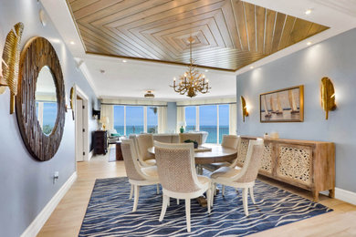 Example of a large beach style porcelain tile and beige floor dining room design in Other with blue walls