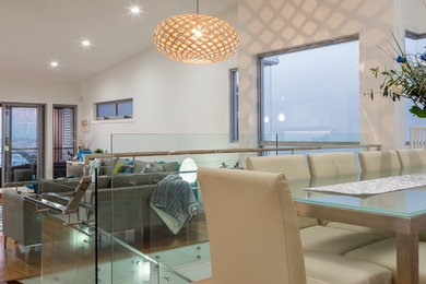 Cette image montre une salle à manger ouverte sur le salon design de taille moyenne avec un mur blanc, parquet clair et aucune cheminée.