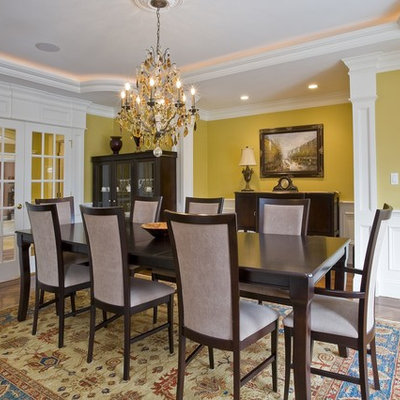 Elegant medium tone wood floor dining room photo in Boston with yellow walls